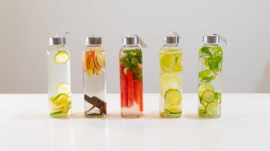 Beyaz masadaki küçük şişelerde taze içecekler.