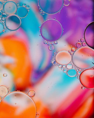 Su üzerinde renkli büyük ve küçük yağ çemberlerinin soyut bir arka planı