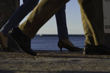 Sahilde yürüyen erkek ve kadın ayaklarının yakın çekimi.