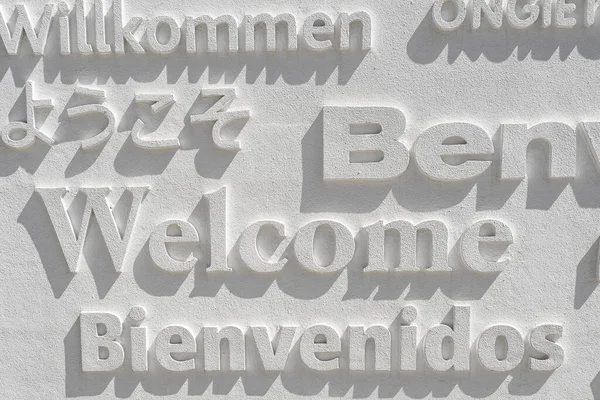 Μια Λέξη Ευπρόσδεκτη Γραμμένο Διάφορες Γλώσσες Ένα Λευκό Τοίχο — Φωτογραφία Αρχείου