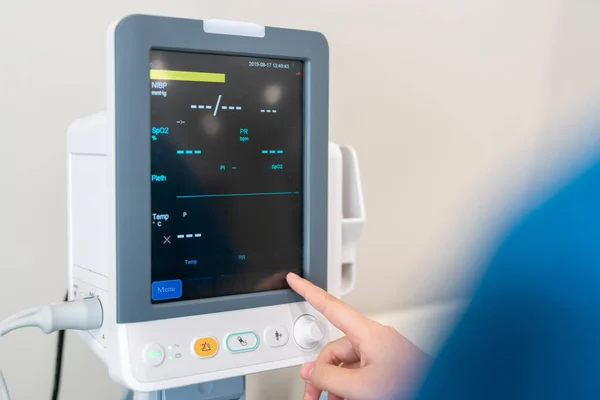 一个医生在一个干净的现代化医院房间里操作重要器官监测器的特写镜头 — 图库照片