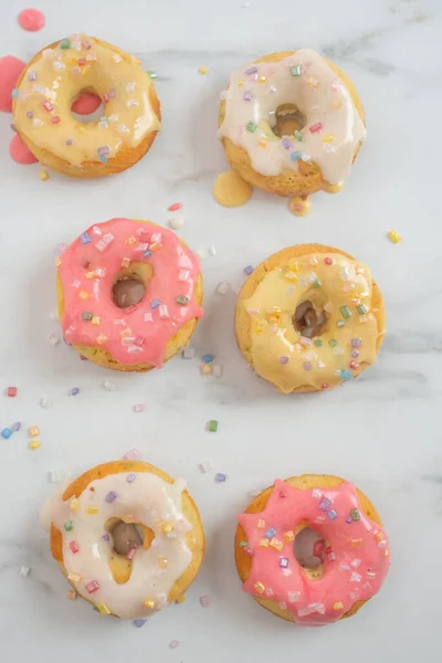 Top View Tasty Creamy Doughnuts Covered Colorful Sprinkles Marble Surface — Stock Photo, Image