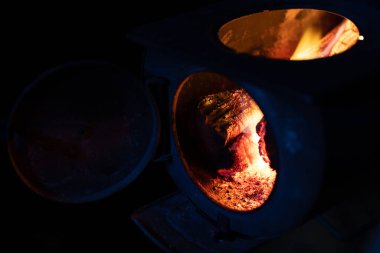 Ormanın yakın çekimi alevler içinde, karanlıkta sobanın üstünde.