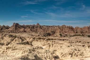 Badlands Ulusal Parkı, Güney Dakota, ABD 'de mavi gökyüzü altında renkli tepeler ve kaya oluşumları