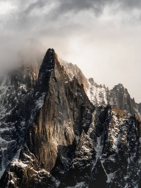 灰色の曇り空の下で雪に覆われた山の頂上の美しい景色 — ストック写真