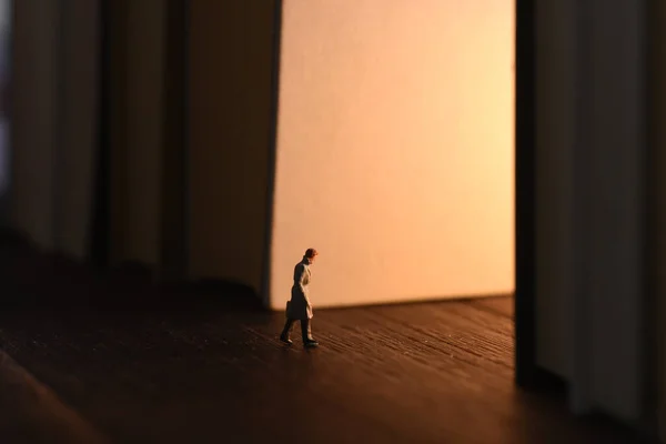 Close Uma Estatueta Homem Caminhando Para Luz Através Dos Livros — Fotografia de Stock