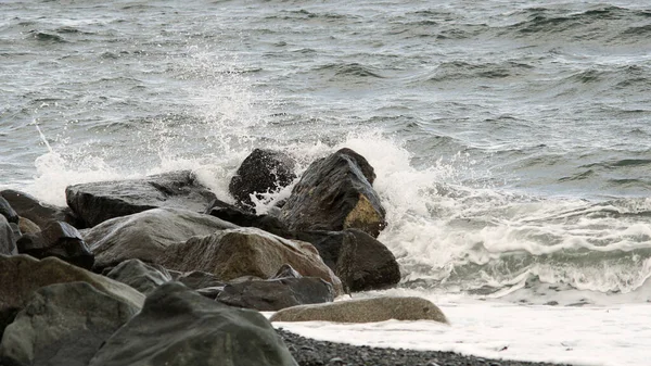 在寒冷的春天 海浪在海滩上拍打着岩石 — 图库照片