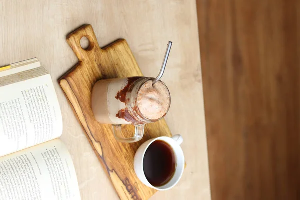 コーヒーショップでコーヒーカップ付きの本の垂直ショット — ストック写真