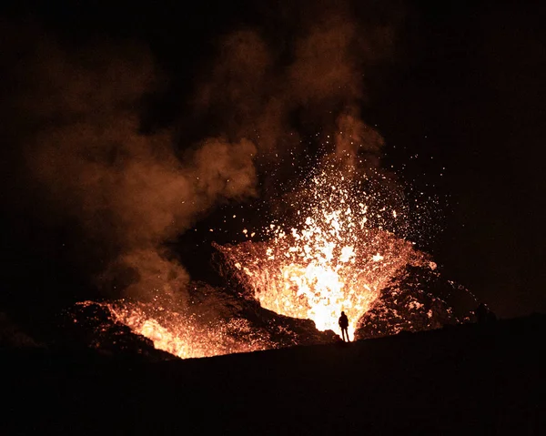一个人在夜间观看火山喷发的轮廓 — 图库照片