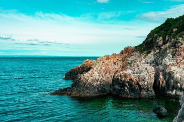 Arka planda kayalıklar olan güzel bir deniz görüntüsü.