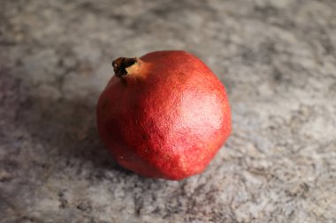 Gri, bulanık arka planda bir nar resmi.