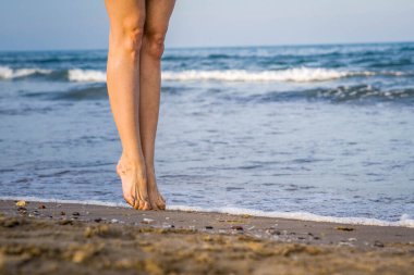 Tanımlanamayan Bale dansçısının resmi. Kısa elbiseli güzel kadın dansçısı. Sahilde Tırmanış yaparken Toes Bale Style 'ı tutuyor.