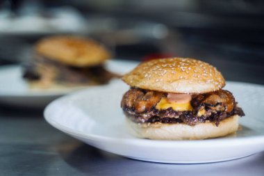 Tabakta bir hamburgerin yakın çekimi.