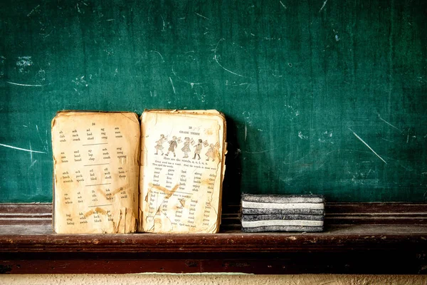 位于北卡罗来纳州塔克塞多市一所废弃学校黑板上的一本三年级的旧书 — 图库照片