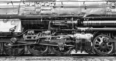 Union Pacific Big Boy lokomotif tekerlekleri ve mekanik parçalarının gri tonda yakın çekimi.