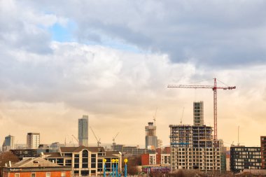 Kentsel binaların manzarası ve Manchester, İngiltere ve İngiltere 'de vinçleri olan yeni yapılar.