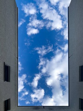 Mavi gökyüzünün altında bulutlu bir binanın alçak açılı görüntüsü.