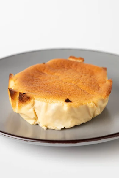 在白色背景上隔离的灰色盘子上的一个美味的奶酪砂锅特写镜头 — 图库照片