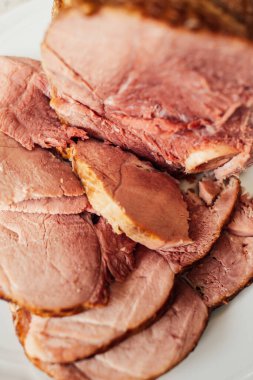 Beyaz tabakta dilimlenmiş Kurobuta kemikli jambon eti