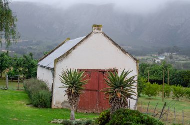 Tarlada eski beyaz bir kulübe.