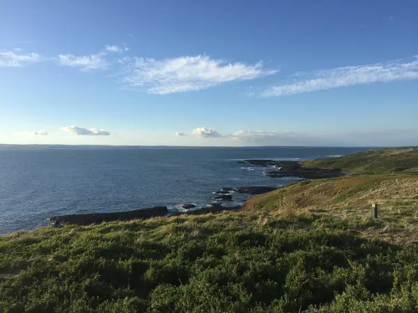 Uma Vista Mar Com Céu Azul Com Pequena Colina Verde — Fotografia de Stock