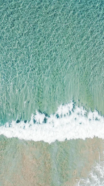 A vertical aerial shot of sea waves