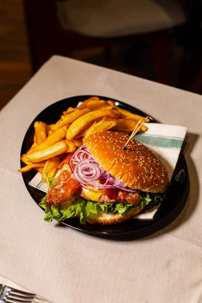 フライドポテトとジューシーなハンバーガーの垂直ショット — ストック写真