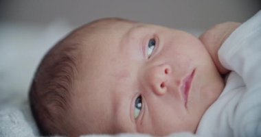 Yeni doğmuş şirin bir bebeğin yatakta uzanmış görüntüsü.