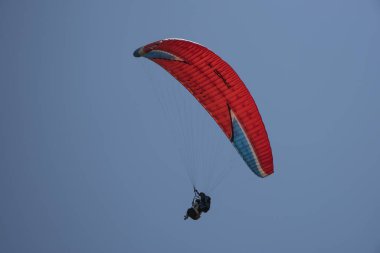Nepal 'de açık mavi gökyüzünde yüzen bir paraglider görüntüsü.