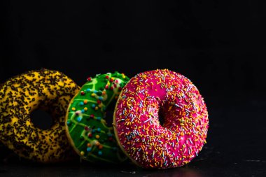 Siyah arka planda izole edilmiş renkli jöleli çörekler