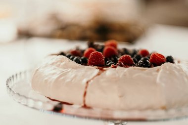 Meyvelerle süslenmiş lezzetli bir pavlova kekinin seçici odak noktası.