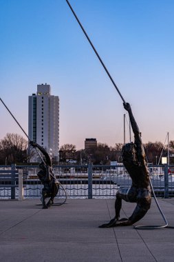 Bir adam ve bir kadın gün batımında ve mavi gökyüzünde ipleri çekiyorlar.