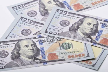 Beyaz bir arka planda yüz dolarlık yığının yakın çekimi.