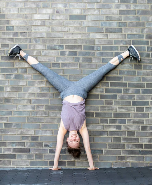 Ung Vit Kvinna Gör Ett Handstativ Framför Stenmur Som Fitness — Stockfoto