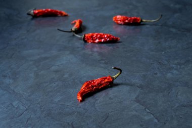Gri bir masada kurutulmuş kırmızı biber resmi.