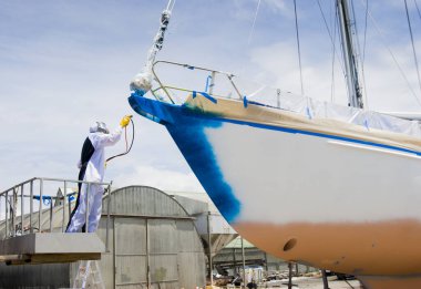 Tam vücut koruması ve yelkenlinin gövdesini boyayan bir sprey boyacı.