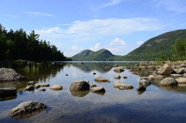 Baharda huzurlu gölün üzerindeki mavi bulutlu gökyüzü