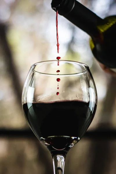 Κόκκινο Κρασί Χύνεται Από Ένα Μπουκάλι Ένα Ποτήρι Κρασί Ένα — Φωτογραφία Αρχείου