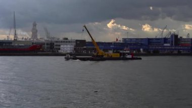 Rotterdam Limanı Bulutlu bir gökyüzüne karşı tekne ve vinçlerle