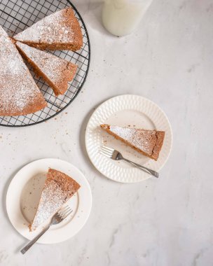 Tabaklarda havuçlu kek dilimleri ve pastaların geri kalanı bir rafta soğuyor..