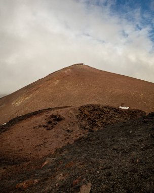 Bulutlu bir gökyüzünün altındaki dağlık bir arazinin güzel bir görüntüsü.