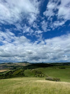 Yazın bulutlu gökyüzünün altında dikey bir manzara.