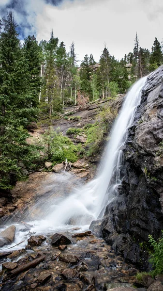 Tiro Vertical Uma Cachoeira Que Flui Penhasco Rochoso Uma Floresta — Fotografia de Stock