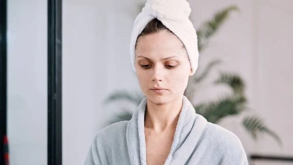 Een Vrouw Met Cosmetisch Masker Het Gezicht Met Een Handdoek — Stockfoto