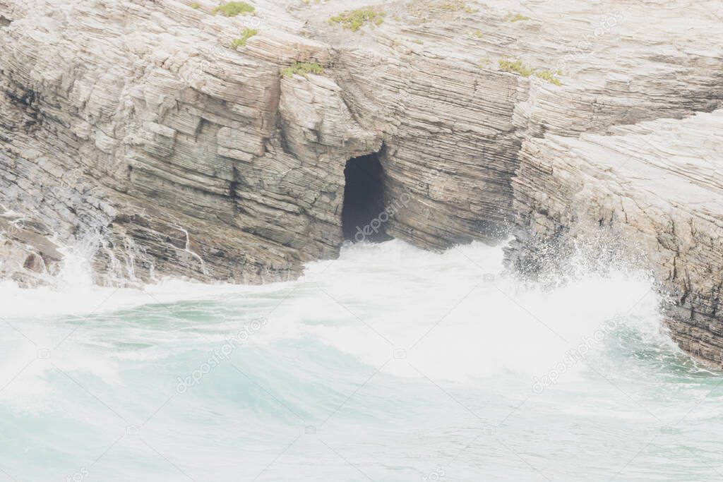 The waves crashing against rocks on a rainy day. Punta Corveira, Lugo, Galicia, Spain.