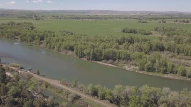 Nehir, tarlalar ve dağlarla çevrili bir arazinin hava görüntüleri.
