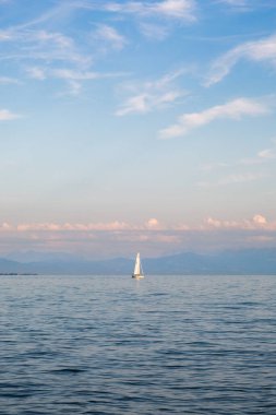 Constance Gölü 'nde bulutlu gökyüzünün altında bir yelkenli gemisinin dikey çekimi.