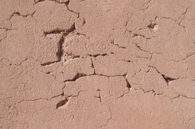 Eski kerpiç duvarındaki çatlakların yakın plan çekimi.