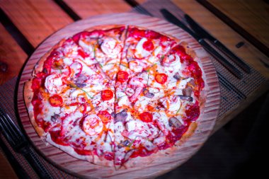 Tahta bir masada taze deniz ürünleri pizzası.