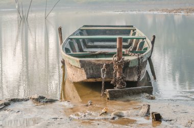 Kışın Tuna nehrinin kıyısına demirlemiş ahşap bir balıkçı teknesi.